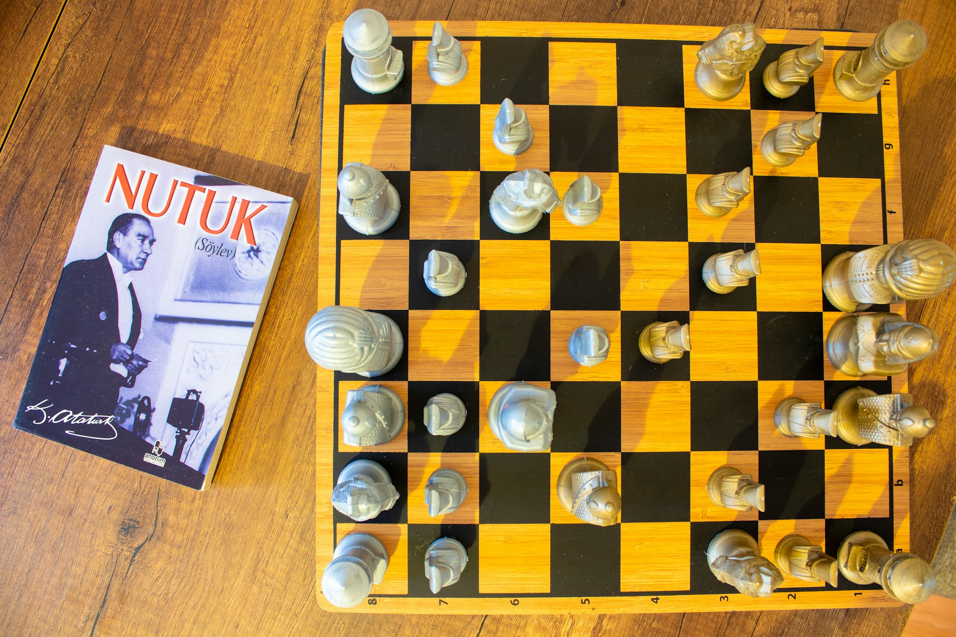 A chess board and a book on a wooden floor